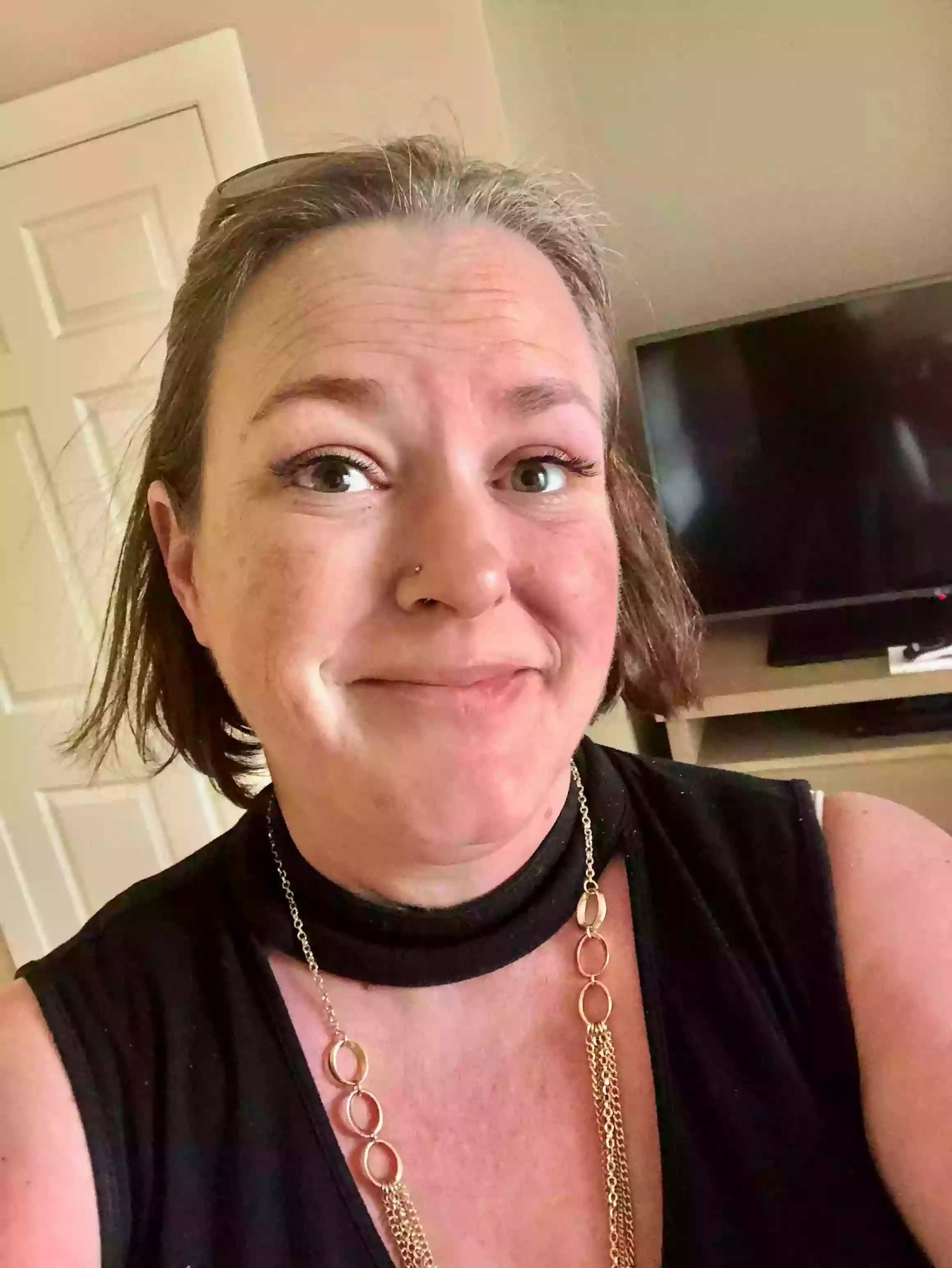 A woman wearing a black shirt and a gold chain necklace