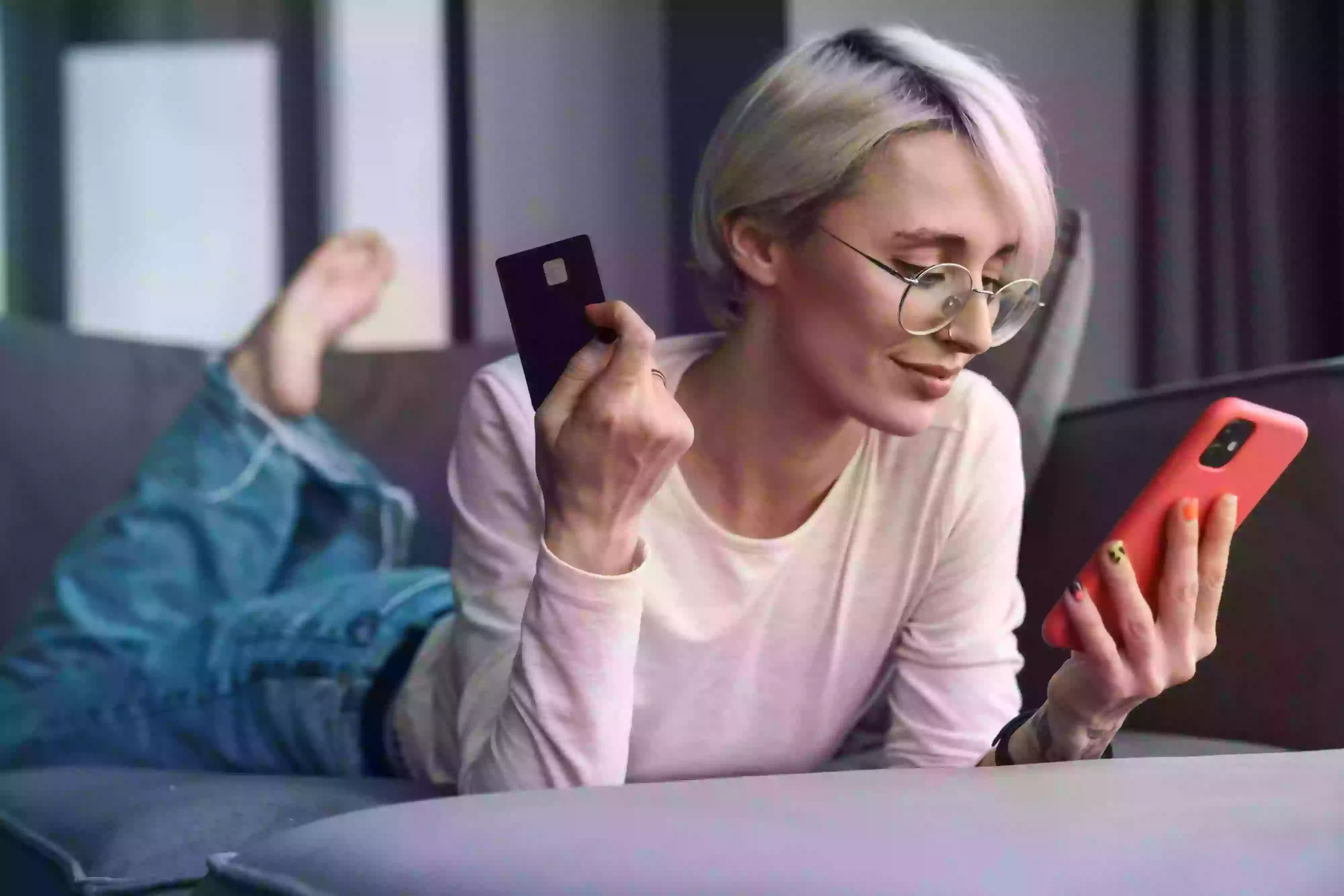 A woman sitting on a couch holding a cell phone